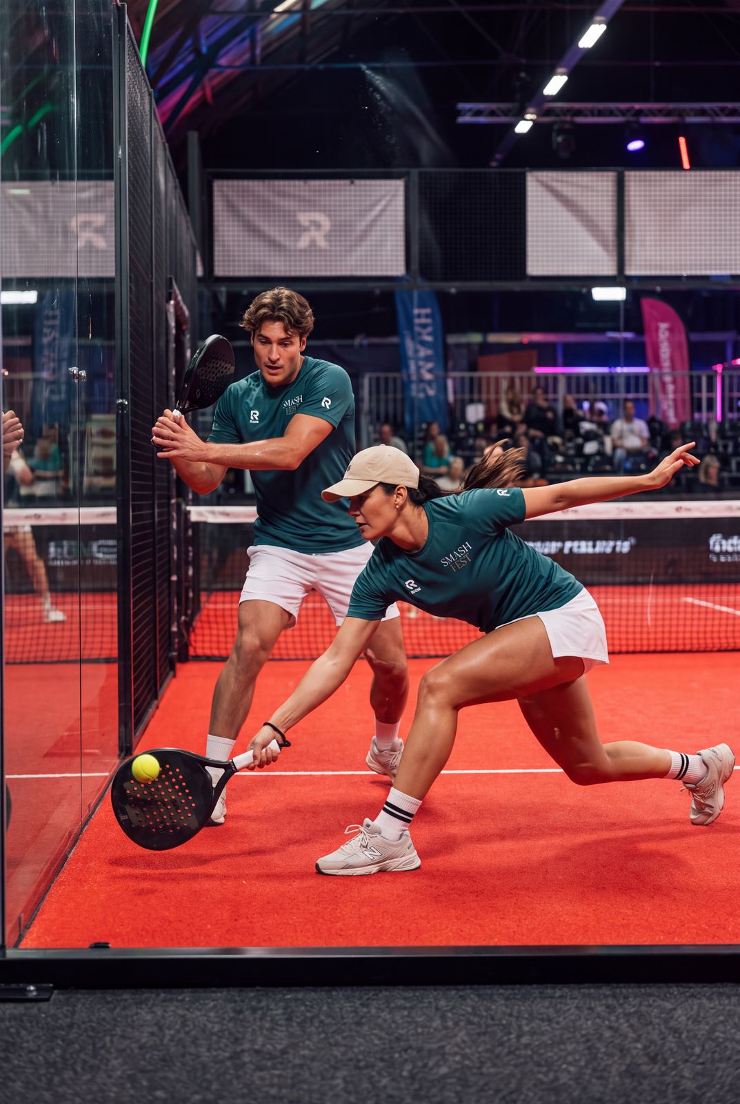 Twee spelers in Smash Fest shirts tijdens een rally op de padelbaan